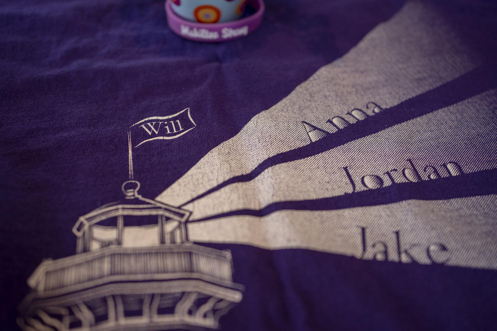 A shirt with an image of a lighthouse and names radiating out from it: Anna, Jordan, Jake. The name Will is on the flag atop the lighthouse