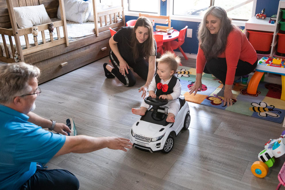 10-month-old Max plays with his mother, Olena Roze, center, and the VanPattens in their home 