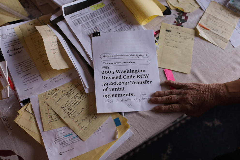 A desk covered in notes and research, the front page reads: 2005 Washington Revised Code RCW 59.20,073: Transfer of rental agreements.