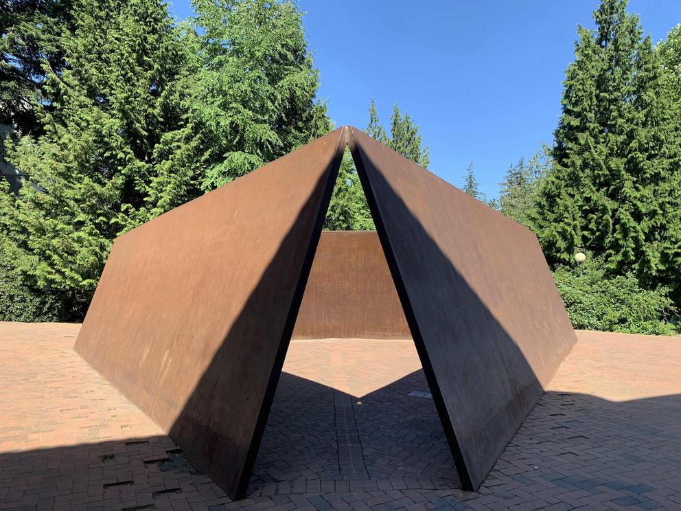 photo of a rusted steel sculpture with sharp triangular angles