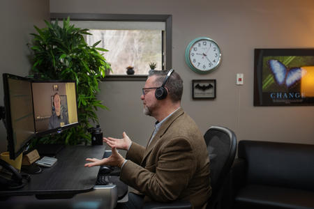 Wayne Pollard video chats with Dr. Matthew Iles-Shih on his computer
