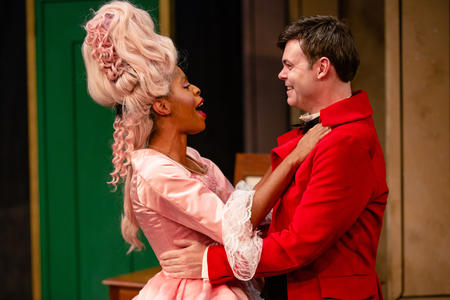 a man in a red waistcoat and a woman in a tall pink wig