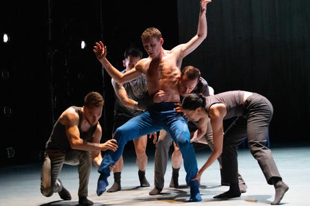 photo of several dancers performing in a group on stage