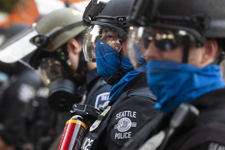 Seattle police wear blue masks and line in a row