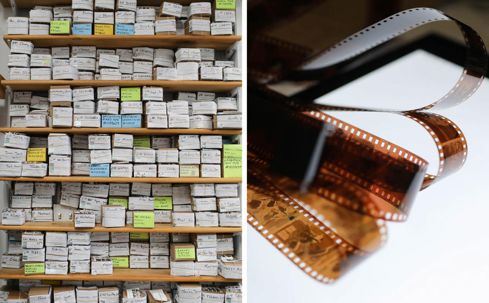 on the left, dozens of boxes of film negatives labeled with names line shelves, at right film negatives are bundled on a light box