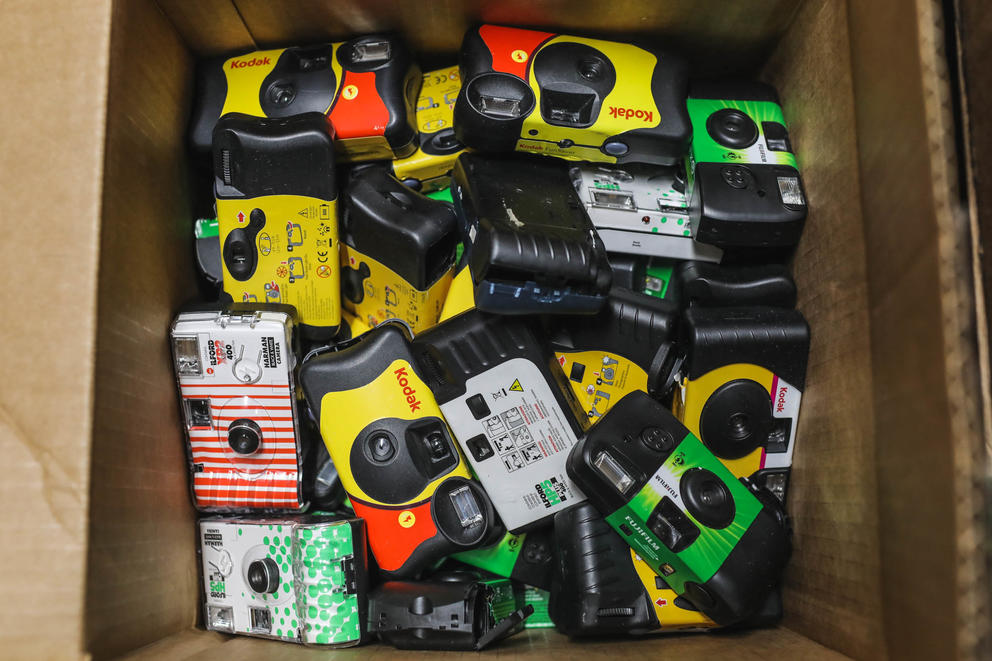 a box full of colorful disposable cameras