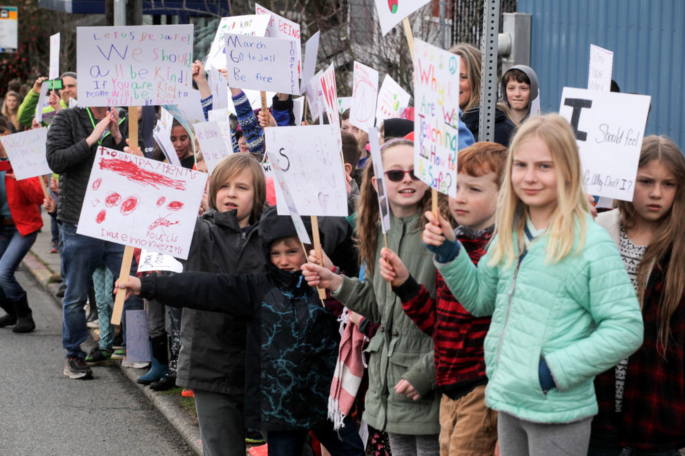 University Cooperative School (K-5) cheer on the high school students as they march from Roosevelt High School to University of Washington