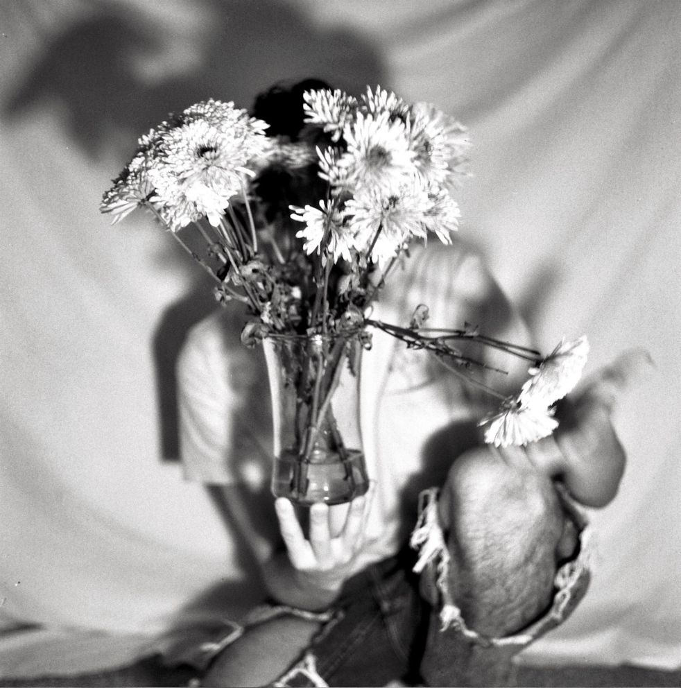 black and white photo of a person holding flowers