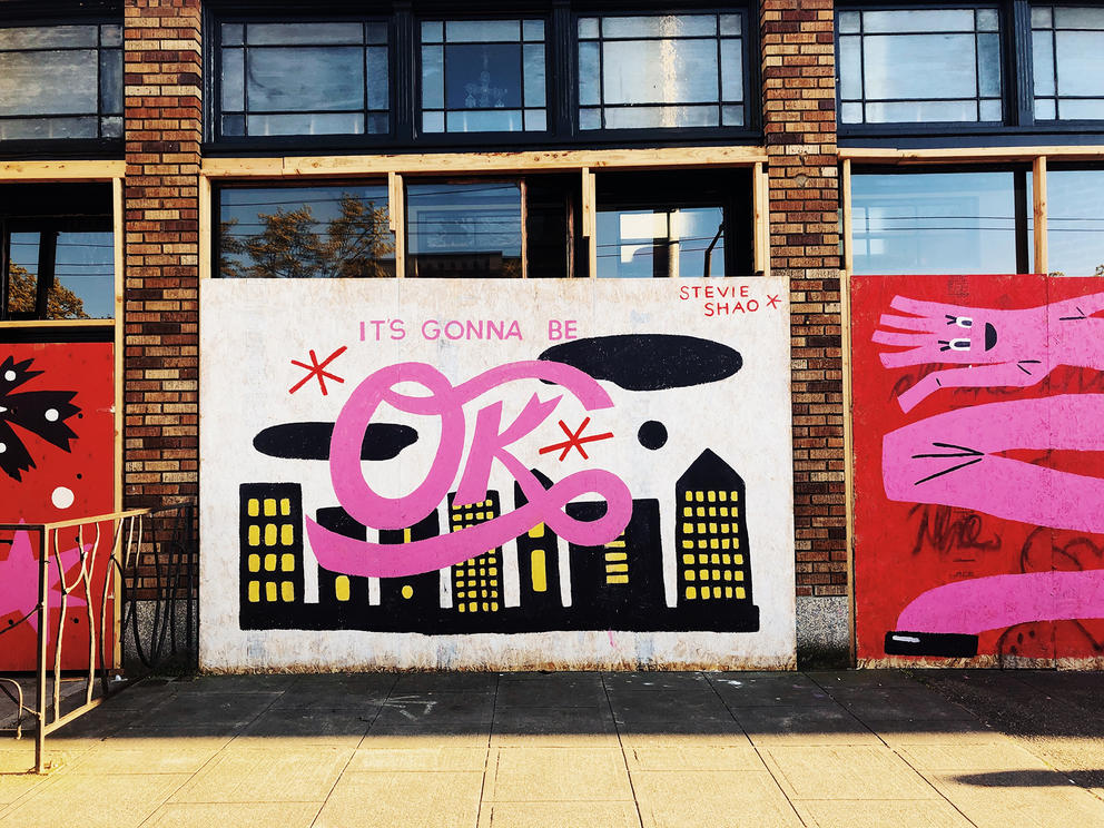 Mural with black downtown image and pink lettering stating: "It's gonna be OK"