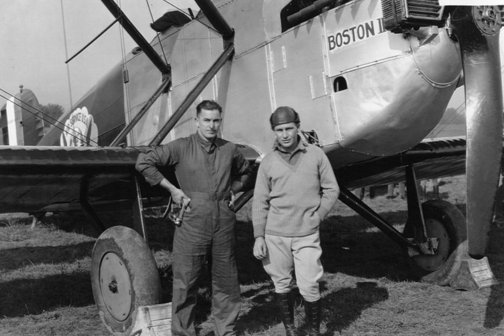 Two pilots pose in front of a World Cruiser bi-plane