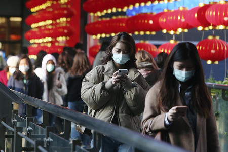 A line of people in respiratory masks