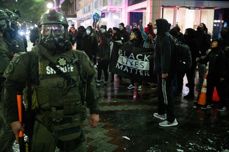 militarized police officer with BLM protesters