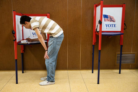 A man filling out his ballot in a Yakima voting booth